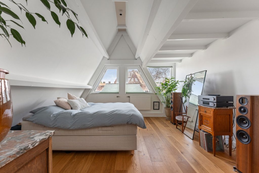 Slaapkamer interieurontwerp met puntdak: architectonisch design zichtbaar van binnenuit door Bouwvorm
